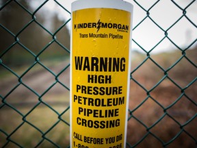 A sign warning of an underground petroleum pipeline is seen on a fence at Kinder Morgan's facility where work is being conducted in preparation for the expansion of the Trans Mountain Pipeline, in Burnaby, B.C.