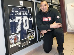Dallas Cowboys' Tyrone Crawford poses with his rookie jersey mounted on the Wall of Athletic Excellence at Catholic Central high school in downtown Windsor on April 5,  2018.