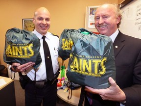 'Rescue backpacks' filled with essentials and targeted for youth at risk are displayed by OPP Staff Sgt. Brad Sakalo, left, and OPP Cmdr. Glenn Miller at the Essex detachment on April 11, 2018.