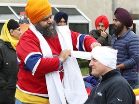 Windsor Mayor Drew Dilkens sits for a turban-wrapping by Harjinder Singh Kandola, president of the Sikh Cultural Society of Metropolitan Windsor, during Sikh Heritage Month and Khalsa Day celebrations at Windsor City Hall Friday April 13, 2018.