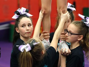 NorthStar Cheer members concentrate on a lift during practice on April 14, 2018.  Members of the local cheerleading company are off to The Summit competition in Florida.