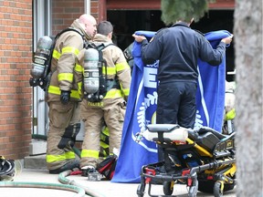 Firefighters and paramedics give emergency medical treatment to an elderly man at the scene of a house fire at 2328 Aubin Rd. on April 18, 2018.