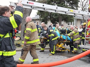 Windsor firefighters, paramedics, and police prepare to take an elderly man to hospital after a house fire at 2328 Aubin Rd. on April 18, 2018.