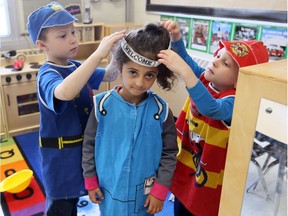 Christ the King Catholic Elementary School JK/SK students Kevin, left, and Kenny help Laneta, centre, with her costume in an "inquiry station" Thursday April 26, 2018.  The inquiry station is one of several new ways of learning.