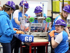 Build A Dream Robotics Team members Madison Vickery, right, and Mackenzie Sulyak in the pits with mentors Adelina Greco, left, Amy Vickery and team member Valerie Alexander, behind, at the Fifth Annual Windsor Essex Great Lakes District FIRST Robotics competition at St. Denis Centre, University of Windsor
