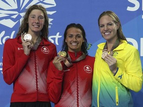 Women's 200m backstroke gold medalist Canada's Kylie Masse, centre, stands with silver medalist and compatriot Taylor Ruck, left, and bronze medalist Australia's Emilt Seebohm on the podium at the Aquatic Centre during the 2018 Commonwealth Games on the Gold Coast, Australia, Sunday, April 8, 2018.