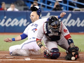 Steve Pearce of the Toronto Blue Jays slides across home plate to score during MLB action as Sandy Leon of the Boston Red Sox fails to come up with the throw at Rogers Centre on April 24, 2018 in Toronto. (Tom Szczerbowski/Getty Images)