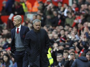 Manchester United manager Jose Mourinho, right, and Arsenal manager Arsene Wenger walk on the pitch at the end of the English Premier League soccer match between Manchester United and Arsenal at the Old Trafford stadium in Manchester, England, Sunday, April 29, 2018.