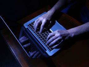 Hands at a laptop computer in a photo illustration.
