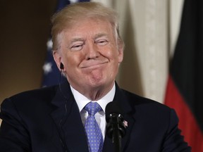 President Donald Trump listens during a news conference with German Chancellor Angela Merkel in the East Room of the White House, Friday, April 27, 2018, in Washington.