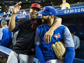 Cleveland Indians designated hitter Edwin Encarnacion (10) laughs with former teammate, Toronto Blue Jays right fielder Jose Bautista, at batting practice in Toronto on Monday, May 8, 2017. (THE CANADIAN PRESS/Nathan Denette)