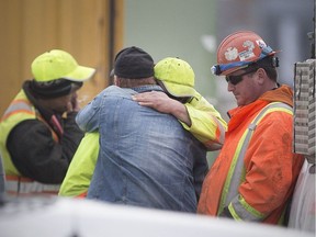 In this April 12, 2018, file photo, workers console each other at Prestressed Systems Inc. on Walker Road where a fatal industrial accident occurred earlier that morning.