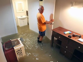 Windsor resident Ray Piche stands in ankle-deep water in his flooded basement on Aug. 29, 2017.