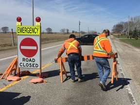 An Essex County highway crew barricades County Road 42 after a serious, single-car crash resulted in a vehicle being submerged in Big Creek on April 22, 2018.NICK BRANCACCIO/ WINDSOR STAR