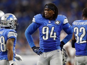 FILE - In this Oct. 23, 2016, file photo, Detroit Lions defensive end Ezekiel Ansah stands in the sideline during the first half of an NFL football game against the Washington Redskins in Detroit. Ansah has signed his franchise tag, signaling his return to the Detroit Lions, the team announced Tuesday, April 17, 2018. Detroit designated the defensive end from Ghana as its franchise player nearly two months ago.