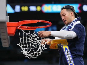 Jalen Brunson of the Villanova Wildcats takes a cut out of the net to commemorate Villanova's 79-62 win over Michigan Wolverines in Monday's NCAA basketball final in San Antonio, Texas. It was Villanova's second title in three years.