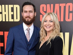 FILe - In this May 10, 2017 file photo, Danny Fujikawa, left, and Kate Hudson arrive at the Los Angeles premiere of "Snatched." Hudson and her musician boyfriend Fujikawa, revealed on Instagram that they're baby will be a girl. It's her third child and her first with Fujikawa.