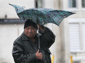 A man struggles with his umbrella in downtown Windsor in this 2011 file photo.