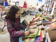 Young reader Sydney Hong, 8, of Windsor, finds plenty to delight her at the big Raise-a-Reader book sale at Windsor Crossing outlet mall on April 28, 2018.