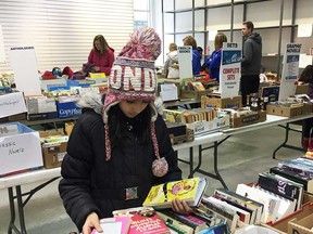 A young reader examines the offerings of the Windsor Star's Raise-a-Reader book sale at Windsor Crossing outlet mall on April 28, 2018.