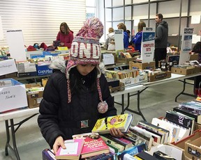 A young reader examines the offerings of the Windsor Star's Raise-a-Reader book sale at Windsor Crossing outlet mall on April 28, 2018.