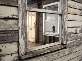 A visitor examines the rebuilt house of Rosa Parks, Sunday, April 1, 2018, at the WaterFire Arts Center, in Providence, R.I. Rosa Parks moved to the house in Detroit in 1957, two years after refusing to give up her bus seat. Years later, the house was abandoned. Her niece bought it off a demolition list for $500 then donated it to artist Ryan Mendoza who reassembled it in Germany. Mendoza returned it to America for a Brown University exhibition, but the show was canceled. The house is making a brief showing on Easter weekend.