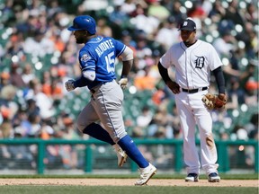 Kansas City Royals' Abraham Almonte (45) rounds the bases past Detroit Tigers third baseman Jeimer Candelario, right, after hitting a grand slam during the sixth inning of a baseball game Sunday, April 22, 2018, in Detroit.