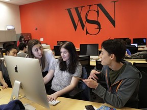 In this Sunday, April 22, 2018, photo, New York University's Washington Square News editor-in-chief Jemima McEvoy, left, talks to deputy managing editor Pamela Jew, center, and managing editor Sayer Devlin, while preparing the weekly's next edition on deadline, in New York. McEvoy has been forced to cut the newspaper by four pages and slice circulation. With the Save Student Newspapers movement, college journalists are speaking up for themselves in a coordinated campaign to combat some of the same forces that have battered newspapers across the country as digital media has imperiled print.