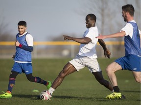 Windsor TFC's Korede Adepitan, centre, carries the ball while teammates Chad white and Surab Akbari close in during practice as the team prepares for Sunday's League1 Ontario men's soccer opener.