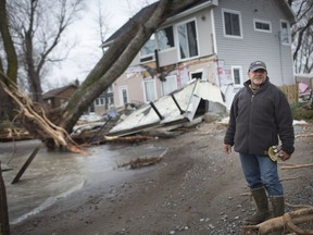 Larry Greco, vice-president of the Marentette Beach Association, on Monday surveys the damage done to homes along the eastern shore of Point Pelee after a strong weekend storm.