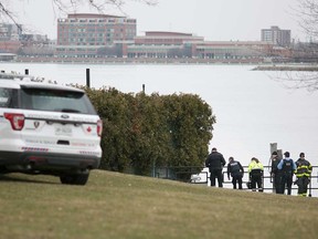 Windsor police officers stand at the edge of the water at Alexander Park on April 9, 2018. A body was recovered from the Detroit River in the area.