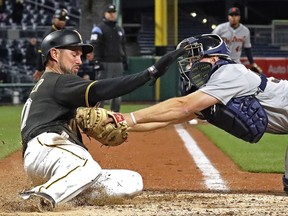 Pittsburgh Pirates' Jordy Mercer, left, scores around the attempted tag by Detroit Tigers catcher John Hicks, on a double by David Freese during the eighth inning of the second baseball game of a doubleheader in Pittsburgh, Wednesday, April 25, 2018.