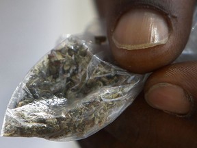 FILE - In this June 29, 2016 file photo, a man holds a bag of synthetic marijuana in Houston. In a report released Tuesday, April 10, 2018, fake marijuana likely contaminated with rat poison has killed three people in Illinois and sickened more than 100 others in the past month.