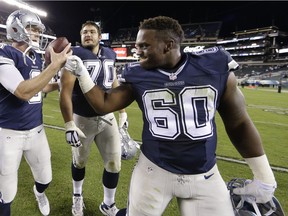 Dallas Cowboys' Brandon Weeden, left, celebrates with Davon Coleman, right, and Zack Martin after an NFL football game against the Dallas Cowboys, Sept. 20, 2015, in Philadelphia.