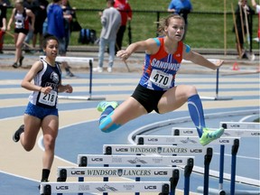 The Sandwich Sabres' Karlie Moore Holy Names' leads Jerriah Kelly during the WECSSAA senior girls' 400-metre hurdles on Tuesday at University of Windsor Stadium. Moore won the race while Kelly finished third.