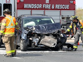 Windsor firefighters clean up after a two-vehicle collision on E. C. Row at Banwell Road on May 18, 2018.