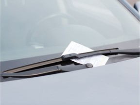 A ticket is shown on the windshield of a vehicle in this photo illustration.