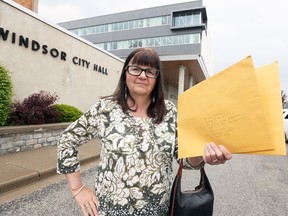 Caroline Taylor holds a complaint for Windsor's integrity commissioner at Windsor's new city hall, shown behind,  on Tuesday May 22, 2018.