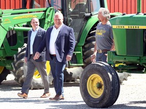 Doug Ford, centre, walks to the podium with local farmer Dave Armstrong, right, and PC candidate Chris Lewis at the Trepanier Farm on Lakeshore Road 235 on May 23, 2018.