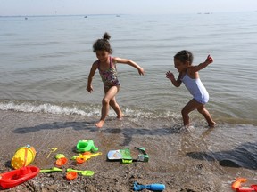Pre-schoolers, like Ava Robinson, 4, left, and her cousin Raeven Robinson, 3, shown May 28, 2018, can escape the heat with a trip to Sand Point Beach, but some students and teachers have been forced to deal with sweltering classrooms this week.