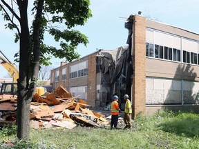 Workers Tom Murtugh and Cameron Knight with Jones Demolition work at the former Concord Public School on Raymond Avenue on May 29, 2018.