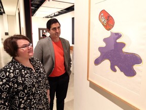 Art Gallery of Windsor curator of contemporary art Jaclyn Meloche, left, and Jose Daiz, chief curator at Pittsburgh's Andy Warhol Museum, view Warhol's 1985 depiction of New Coke during a May 31, 2018, unveiling of new exhibits.