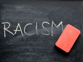 The word 'racism' on a blackboard is erased in this photo illustration.