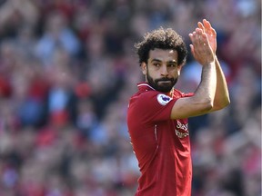 Liverpool's Egyptian midfielder Mohamed Salah applauds fans as he is substituted during the English Premier League football match between Liverpool and Brighton and Hove Albion at Anfield in Liverpool, north west England on May 13, 2018.