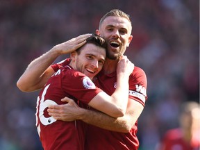 Liverpool's Scottish defender Andrew Robertson (L) celebrates after scoring with Liverpool's English midfielder Jordan Henderson during the English Premier League football match between Liverpool and Brighton and Hove Albion at Anfield in Liverpool, north west England on May 13, 2018.