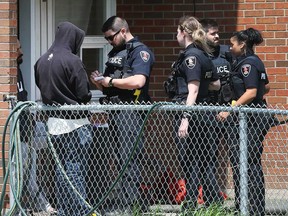 Windsor police officers speak with individuals who may have seen what happened in an altercation on Bloomfield Road on May 5, 2018.