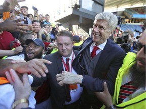 Outgoing Arsenal manager Arsene Wenger, centre right, says goodbye to the fans after the English Premier League soccer match between Arsenal and Huddersfield Town, at the John Smith's Stadium, in Huddersfield, England, Sunday, May 13, 2018. (Mike Egerton/PA via AP) ORG XMIT: LON849