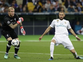 Real Madrid's Karim Benzema, right, scores against Liverpool goalkeeper Loris Karius during the Champions League Final soccer match between Real Madrid and Liverpool at the Olimpiyskiy Stadium in Kiev, Ukraine, Saturday, May 26, 2018.