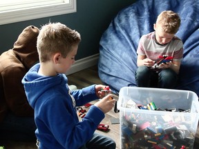 From left, ‘Smiles,’ a foster child in the care of the Windsor-Essex Children’s
Aid Society, plays Legos with foster brothers Zach and Nathaniel Dennison.
“We like a lot of the same things,” Zach says. “I love him.”