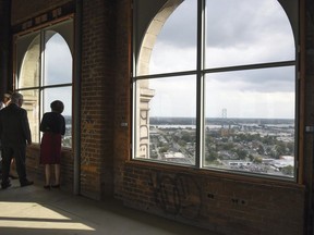 FILE- In this Sept. 13, 2017, file photo, guests peer out from Michigan Central Station's 13th floor during Detroit Homecoming VI in Detroit. People living and working near the Michigan Central Station in Detroit are excited that the Ford Motor Co. is considering buying the massive old building, which has sat vacant for 30 years.